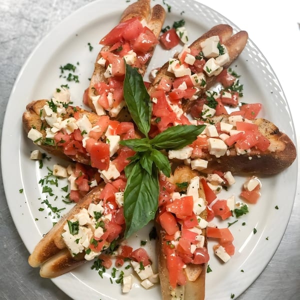 Tony's Pizza bruschetta with diced tomatoes, mozzarella, and basil on toasted bread.